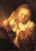 REMBRANDT Harmenszoon van Rijn Young Woman Trying on Earrings oil on canvas